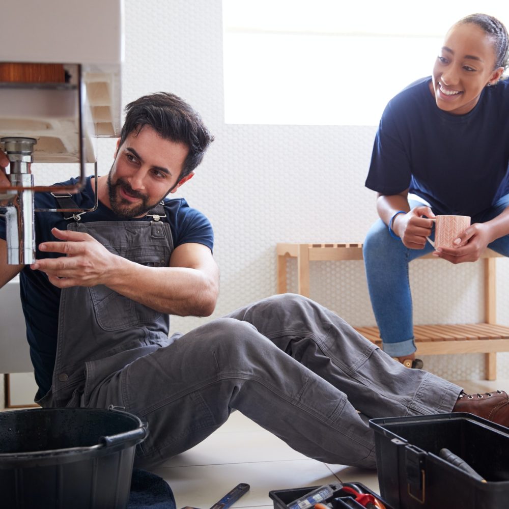 male-plumber-teaching-female-apprentice-to-fix-leaking-sink-in-home-bathroom.jpg